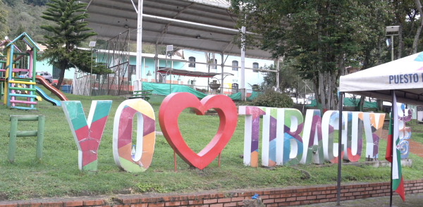 Fotografía de aviso que dice yo amo a Tibacuy, con un corazón incrustado y letras altas de colores sobre un césped